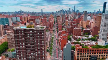 ABD 'nin New York kentinin yukarısındaki pitoresk caddeden çok sayıda araba geçiyor. Arkaplanda gri bulutlu gökyüzünün altında gökdelenler yükseliyor..