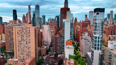 Gri bulutlu bir günde güzel New York manzarası. Yüksek binaların tepesinde yükselen insansız hava aracı görüntüleri ve çatılarda güzel dinlenme yerleri var..