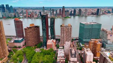 Nehrin rıhtımına, yüksek binalar üzerinde durarak yaklaşıyorlar. Birçok araba nehir boyunca yol boyunca hareket ediyor. New York, ABD 'nin hava perspektifi.
