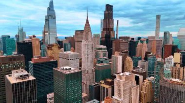 New York şehir merkezindeki gökdelenlerin ve gökdelenlerin tepelerine bakın. Metropolün üstündeki bulutlu gökyüzü.