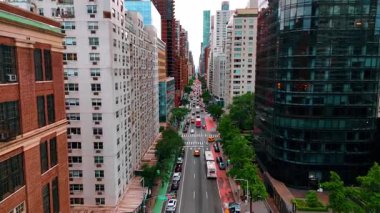 Yüksek binalar boyunca cadde boyunca hareket eden araba akışını takip ediyoruz. New York, ABD 'de trafiği yoğun olan bir cadde..