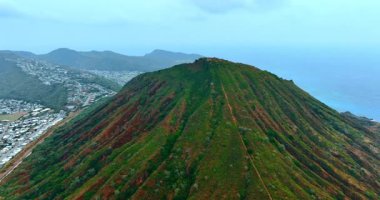 Güzel Honolulu, Hawaii, ABD 'deki Elmas Kafa Krateri' nin yeşil yamaçlarında yükseliyor. Arka planda şehrin sisli manzarası.