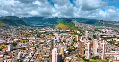 Sıcak güneşli bir günde Honolulu, Hawaii, ABD 'nin muhteşem manzarası. Arkaplanda yeşil dağların üzerinde yağmurlu bulutlar toplandı. Hava görünümü.