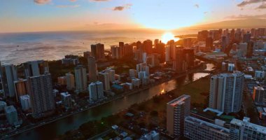 Pasifik Okyanusu 'nda güneş ufuktan batar. İnsansız hava aracı günbatımında Honolulu, Hawaii, ABD şehir manzarasının üzerinde..