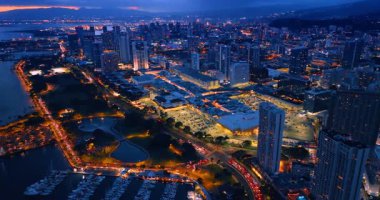 Akşam vakti güzel Honolulu, Hawaii, ABD 'nin muhteşem manzarası. İnsansız hava aracı, alacakaranlıkta ışıl ışıl şehrin üzerinde..
