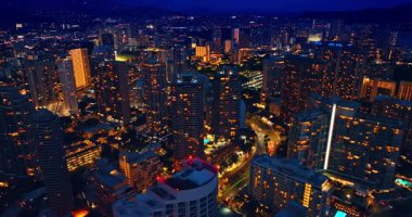 Geceleri modern Honolulu, Hawaii, ABD 'nin hayat dolu yaşam tarzı. Parlak şehrin harika bir manzarası ve muhteşem bir aydınlanma. Hava perspektifi.