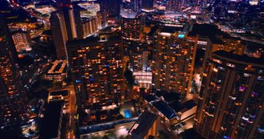 Pencerelerinde ışıklar olan çok katlı apartman bloklarından uzaklaşmak. Modern Honolulu 'nun güzel şehir manzarası, Hawaii, ABD geceleri. Hava görünümü.