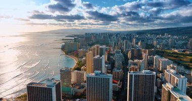 Honolulu, Hawaii, ABD manzarası üzerinde dramatik bulutlar gökyüzünü kaplıyor. Gün batımında Waikiki sahiline yavaş dalgalar akacak. Hava perspektifi.