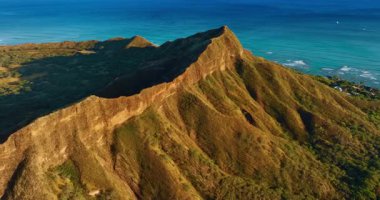 Elmas Kafa Krateri 'nin engebeli yamaçları batan güneşle aydınlanır. Honolulu, Hawaii, ABD 'nin ünlü görüntüsünün üzerinde insansız hava aracı uçuşu..