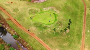 Golf sahasında duran birkaç oyuncuya yaklaşıyoruz. Honolulu, Hawaii, ABD 'deki spor sahasının üstündeki İHA görüntüleri..