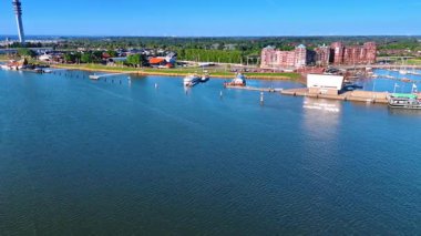 Markermeer Gölü 'nün sakin suları üzerinde güzel bir sahille uçuyor. Hollanda, Lelystad 'daki gemilere, limana ve telekom kulesine bakın..
