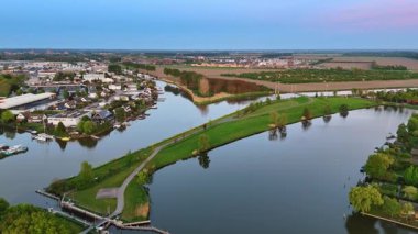 Tarımsal tarlalar arasındaki kanallardaki köy. Gün batımında Hollanda, Vinkeveen 'e hava perspektifi.