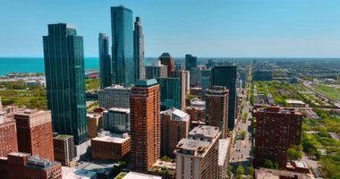 Chicago, Illinois, ABD 'deki panoramada yüksek binalar ve kuleler. Arabalar geçerken sokağın yukarısına iniyorlar.