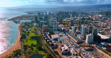 Honolulu, Hawaii, ABD 'nin pitoresk şehir manzarası üzerinde uçuş. Kıyı kenarındaki güneşli şehrin engin manzarası..