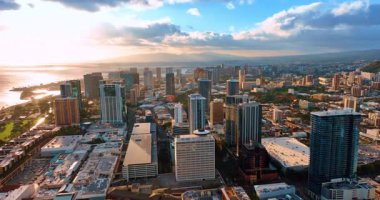 Güneşin batışının göz kamaştırıcı ışığı Honolulu, Hawaii, ABD manzarasını kaplıyor. Panorama üzerinde güzel bulutlar. Hava görünümü.