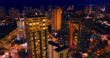 Waikiki, Honolulu, Hawaii, ABD 'nin ışıltılı manzarası. Gece güzel aydınlatılmış şehrin üzerinden uçun..