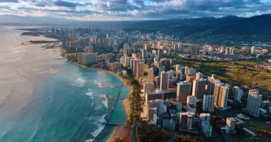 Gün batımında Oahu, Hawaii sahiline daha yakın uçacağız. Dalgalar yavaşça Waikiki sahiline ulaşır. Hava görünümü.