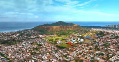 Mavi su manzarasının arkaplanındaki muhteşem volkanik elmas başlıklı krater manzarası. Kentsel yerleşim alanının üzerindeki uçuş Honolulu, Hawaii, ABD 'nin ünlü simgesine yaklaşıyor..