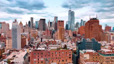 Modern New York, ABD 'nin çeşitli mimarisi. Şehir merkezindeki gökdelenleri gören şehir merkezindeki binaların üzerinden insansız hava aracı uçuşu..