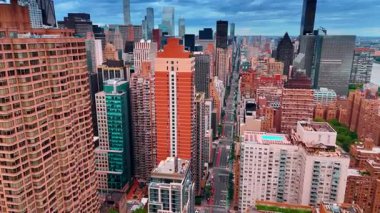 Yüksek binalarla çevrili uzun düz caddenin üzerinden geçiyor. New York, ABD şehir merkezindeki bulvar üzerinde uçuş.