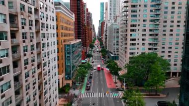 Modern binaların cephelerinde ve cephelerinde birden fazla arabalarla güzel, canlı caddenin üzerinde uçmak. New York Bulvarı, ABD.