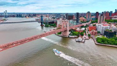 Motorlu tekne Brooklyn Köprüsü 'nün altından geçiyor. Modern New York, ABD 'nin su taşıma ve su yolları hakkındaki geniş perspektifi.