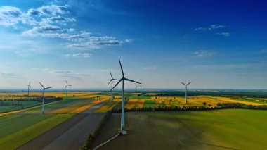 Tarımsal alanda rüzgar türbinleri dönüyor. Rüzgâr değirmenleri olan güzel bir kırsal. Hava görünümü.
