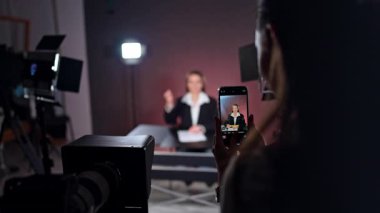 Stüdyoda masa başında oturan bir bayanın telefon kayıtları. Blogger, Soffits 'in ışığında bir video kaydediyor. Bulanık arkaplan.