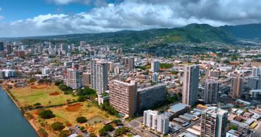 Güneşli Honolulu, Hawaii, ABD 'de hava perspektifi. Beyaz tüylü bulutlar yeşil dağlarda yuvarlanıyor..