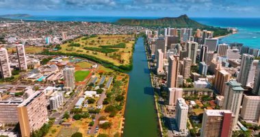 Waikiki tatil beldesini Hawaii, ABD 'deki Honolulu' dan ayıran Ala Wai Kanalı üzerinden uçuş. Arkaplanda ünlü elmas başlıklı kratere yaklaşıyoruz..