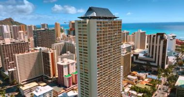 Çatıda güneş panelleri olan yüksek binaların etrafında uçmak. Honolulu, Hawaii, ABD 'deki Waikiki tatil beldesinin mimarisi.