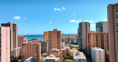 Yüksek katlı bir otel ve Waikiki tatil köyündeki apartman blokları. Honolulu, Hawaii, ABD 'de modern lüks bir bölgenin binalarının tepesindeki insansız hava aracı görüntüleri..