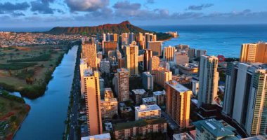 Waikiki 'deki gökdelenlerin yüzleri batan güneşle renklenir. Honolulu, Hawaii, ABD 'deki Elmas Kafa Krateri' ne yaklaşan İHA görüntüleri..