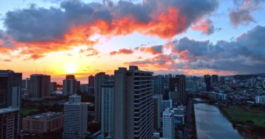 Batan güneşin renklendirdiği güzel kümülüs bulutları. Gün batımında Honolulu, Hawaii, ABD 'nin üzerinde yükseliyor..