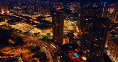 Geceleri hayat dolu bir şehir. Waikiki, Honolulu, Hawaii, ABD 'nin işlek yollarında birden fazla araç çalışıyor. Metropolün gece hayatı havadan bakıldığında.