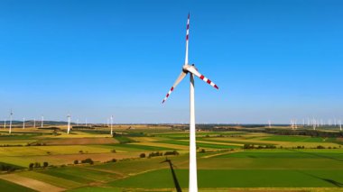 Rüzgarda dönen kırmızı çizgili rüzgar türbinleri. Rüzgâr tarlalarının hava manzarası. Yeşil enerji kavramı.