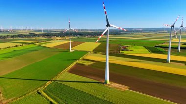 Rüzgâr türbinleri takılı renkli tarlaların tarımı. Rüzgar tarlalarına temiz enerji üreten hava perspektifi.