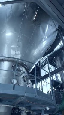 Süt fabrikasının büyük çelik yapısı. Modern gıda boru hattı teknolojisi. Dikey video