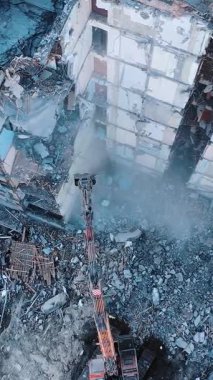 Yıkılmış evin inşaatı. Kazıcıyla yıkıcı yıkım binası. Dikey video