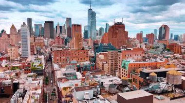 Modern New York, ABD 'deki mahallelerin çatıları üzerinde uçuş. Arkadaki gökdelen silueti. İnsansız hava aracı görüntüleri.