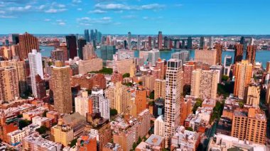 Güneşli bir günde yoğun inşa edilmiş metropolün üzerinde uçmak. New York 'un çeşitli manzaraları East River' ın rıhtımında..