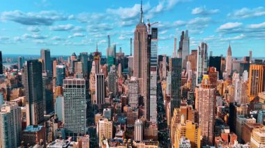 İnşa edilen bir gökdelene daha yakın uçmak. Binanın tepesine bir vinç yerleştirildi. Empire State Binası arkada. Manhattan 'ın şehir panoraması, New York, ABD.