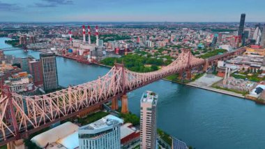 New York, ABD 'deki güzel Queensboro Köprüsü' ne daha yakın uçuyor. Gün batımında şehrin engin manzarasına hava perspektifi.