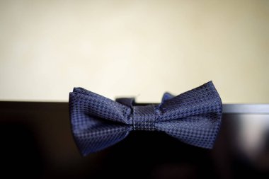 Yüzeyde duran zarif papyon. Şık, mavi bir papyon parlak, koyu bir yüzeyin kenarında duruyor, deseni ve tasarımı gözler önüne seriliyor..