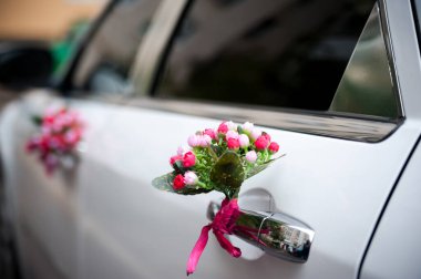 Çiçek desenli düğün arabası. Renkli çiçek süslemeleri dışarıda park etmiş bir düğün arabasının zarafetini artırır..