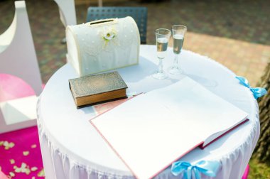 Düğün dekoru ve misafir defteri. Güzelce hazırlanmış bir masada bir misafir kitabı, şampanya bardakları ve düğün resepsiyonunda büyüleyici bir kart kutusu vardır..