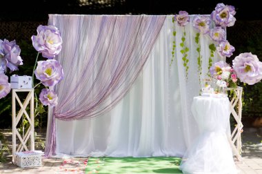 Olaylar için çiçek arkaplanı. Parlak ve zarif çiçek arkaplanı, mor çiçekler ve perdeler, şenlikli bir toplantı veya fotoğraf fırsatı için ideal..