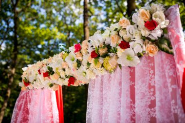 Woodland Çiçekli Düğün Sunağı. Pembe dantel ve canlı çiçeklerle süslenmiş güzel bir düğün sunağı. Gün boyunca sakin bir ormanda geçiyor..