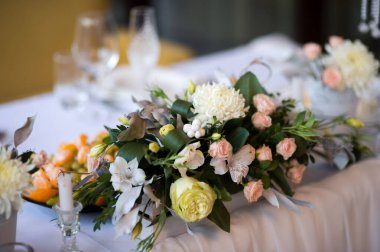 Etkinlikler için çiçek süsü. Çiçeklerin çarpıcı bir düzeni bir ziyafet masasını süslüyor ve etkinliğin şenlikli atmosferini artırıyor..