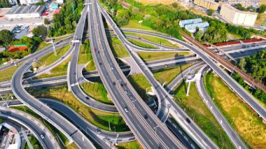 Avrupa 'da karmaşık otoyol kavşağı. Aydınlık bir günde birden fazla şerit ve aracın farklı yönlere hareket ettiği yoğun bir otoyol kavşağının havadan görüntüsü.